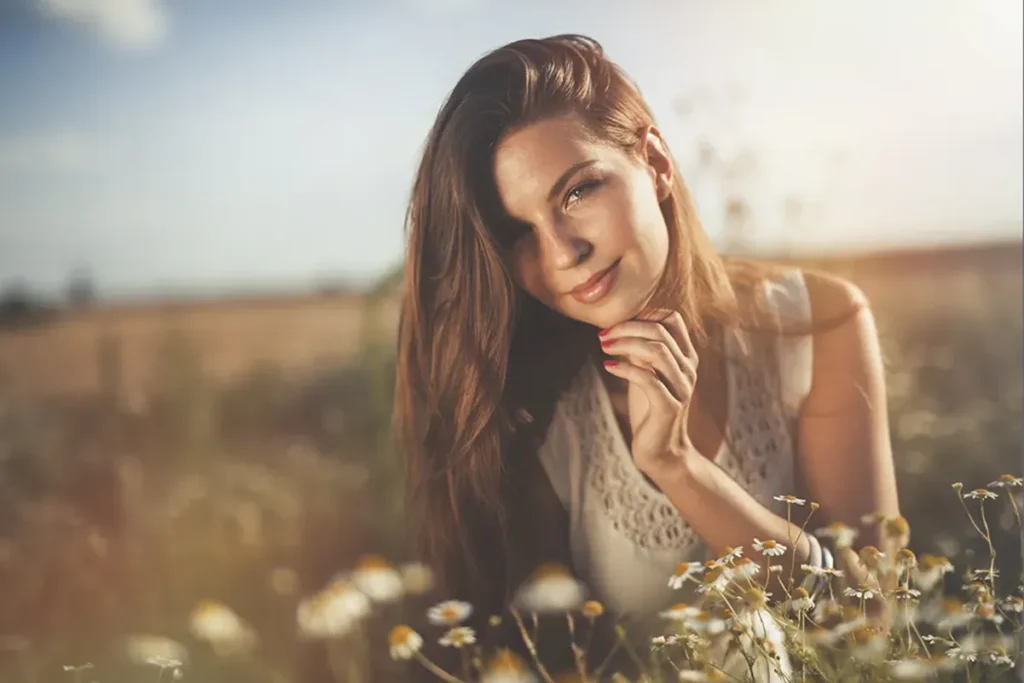 A woman in a field who followed our summer skincare guide.